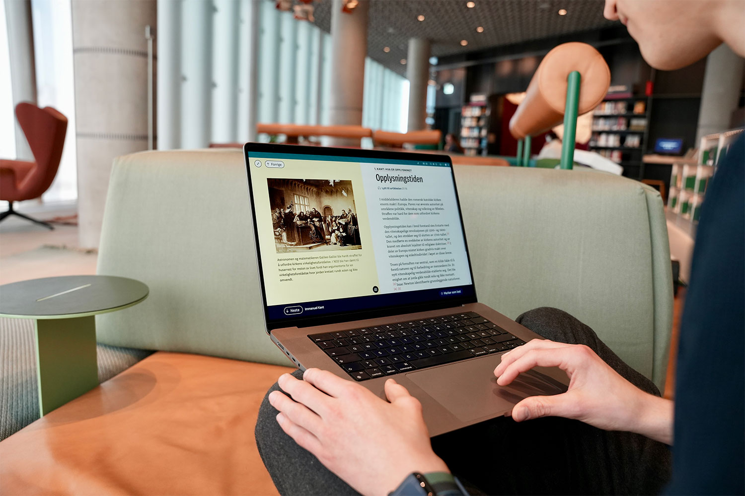 Bildet viser en student som sitter på PCen sin og leser fra Kunne Exphil. Han leser om opplysningstiden, som er pensum i exphil.