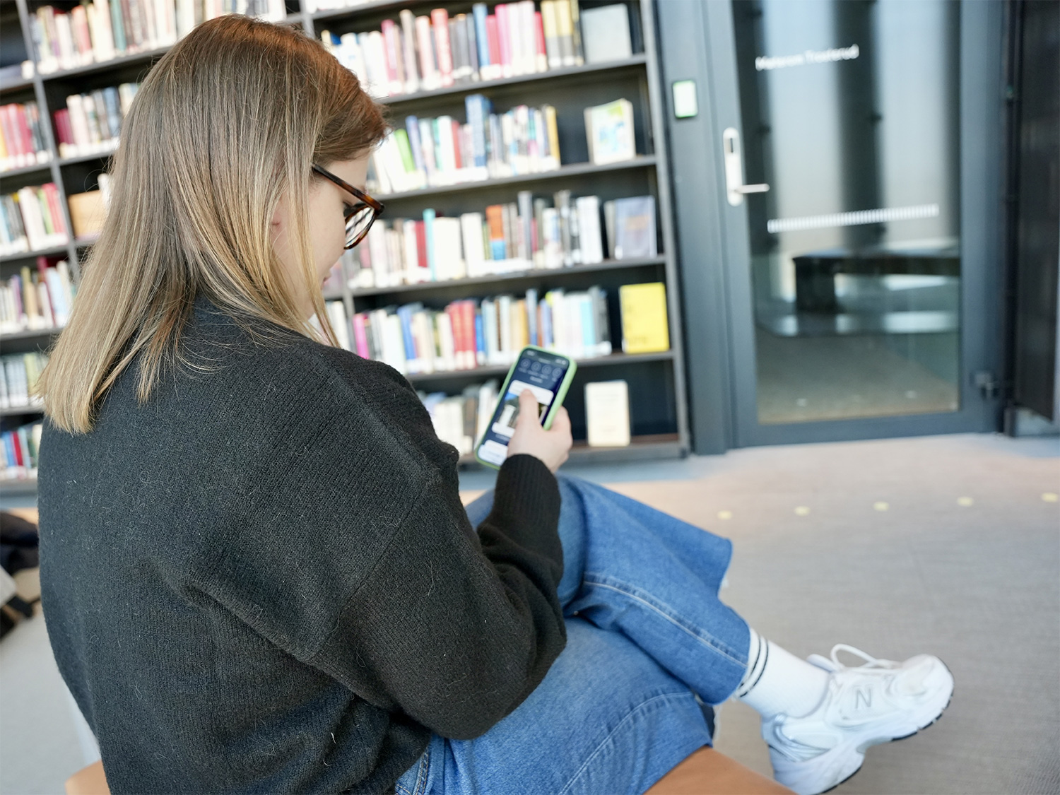 Student som leser fra kunne.no på mobilen.